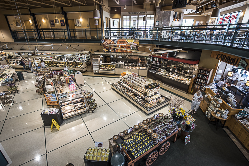 Interior view of the store form a second floor balcony. you can see islands of produce, meats, and cheese and the Caribou Coffee shop.
