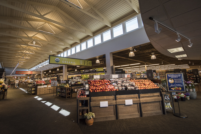 A large produce section with many high square windows running down the length of the top of the wall.